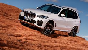 A white BMW X5 parked on rocky terrain