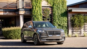 A gray 2020 Lincoln Aviator midsize crossover SUV parked outside a modern ivy-covered home