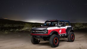 The red-white-and-blue 2021 Ford Bronco 4600 racer in the desert at night