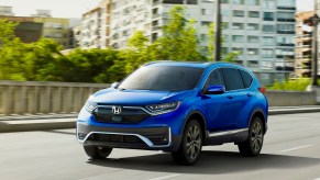 A blue 2021 Honda CR-V Touring compact SUV traveling on a city bridge