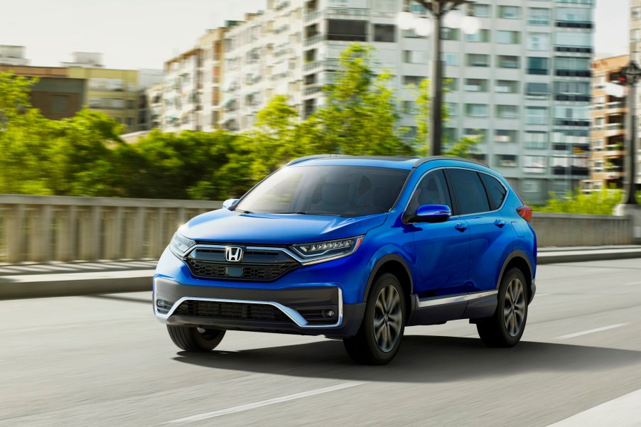 A blue 2021 Honda CR-V Touring compact SUV traveling on a city bridge