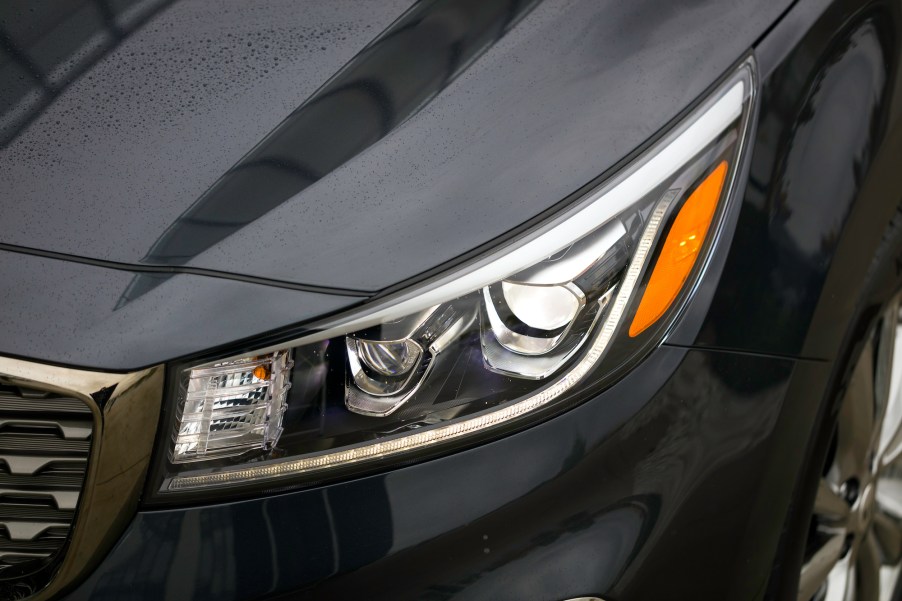 The driver's-side headlight on a dark-colored 2021 Kia Sedona