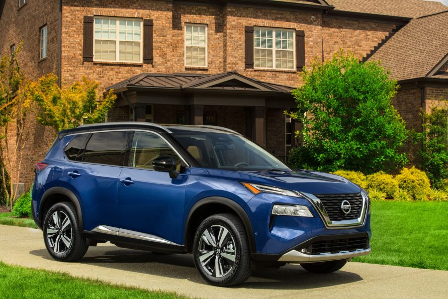 A blue 2021 Nissan Rogue parked in front of a house