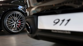 Two black 2021 Porsche 911 cars on display in a showroom