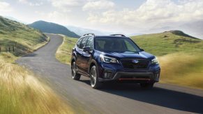 A black 2021 Subaru Forester driving down a country road