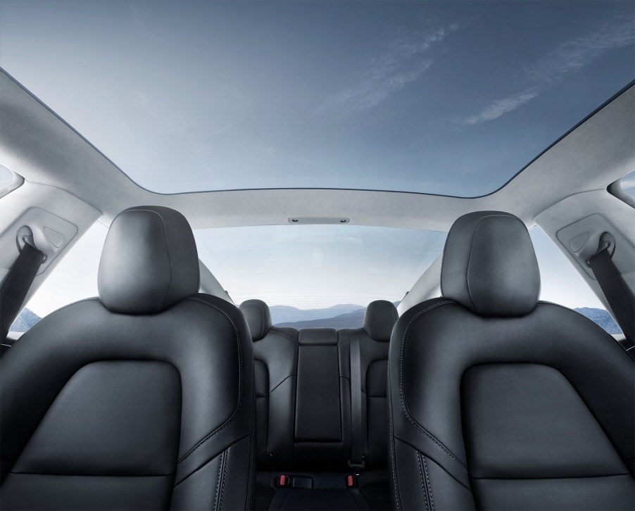 A 2021 Tesla Model 3's interior glass roof showing a blue sky with wispy clouds