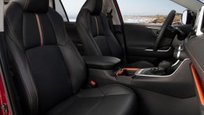 The black leatherette front seats of a 2021 Toyota RAV4 Adventure model with red accents