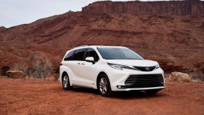 A white 2021 Toyota Sienna Limited minivan parked on red dirt in front of a butte