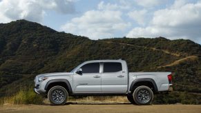 A silver 2021 Toyota Tacoma Trail Edition on display in front of a mountain range