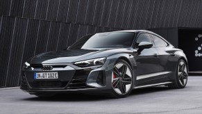 A dark-gray 2022 Audi RS E-Tron GT by a black building