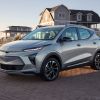 A silver 2022 Chevrolet Bolt EUV by a beach house at sunset