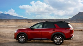 A red 2022 Nissan Pathfinder parked on a dirt road