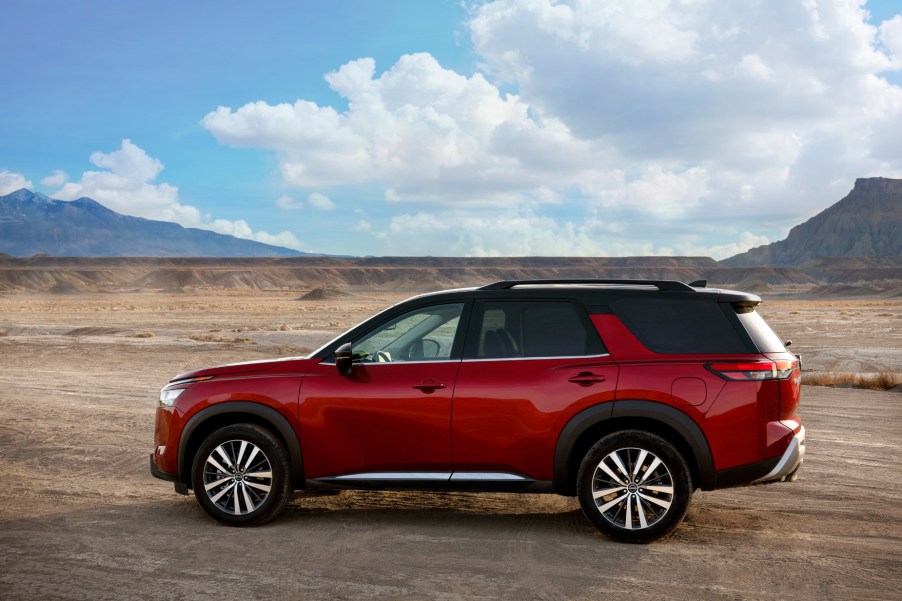 A red 2022 Nissan Pathfinder parked on a dirt road