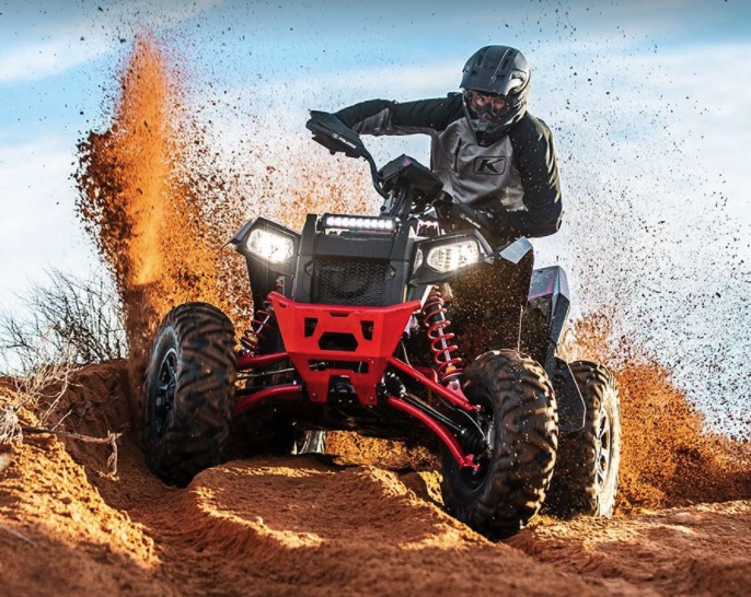 a polaris scrambler xp 1000 S ATV kicking up sand at speed on a trail in the desert