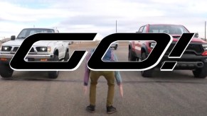 first-gen toyota tacoma pickup truck and the 2021 Ram 1500 TRX about to take off in a drag race