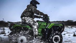 a bright green honda fourtrax foreman rubicon in the snow