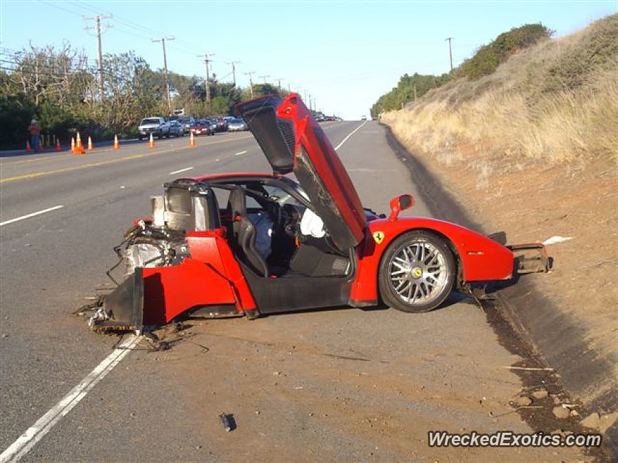 An image of a crashed Ferrari Enzo on the side of the road.