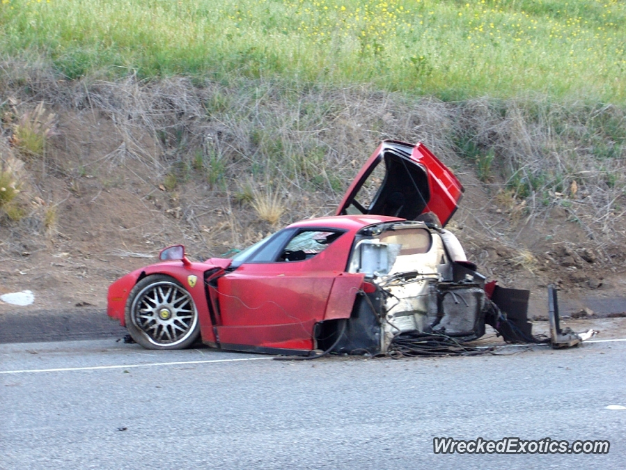 An image of a crashed Ferrari Enzo on the side of the road.