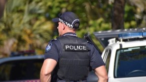 A police officer standing outside in uniform.