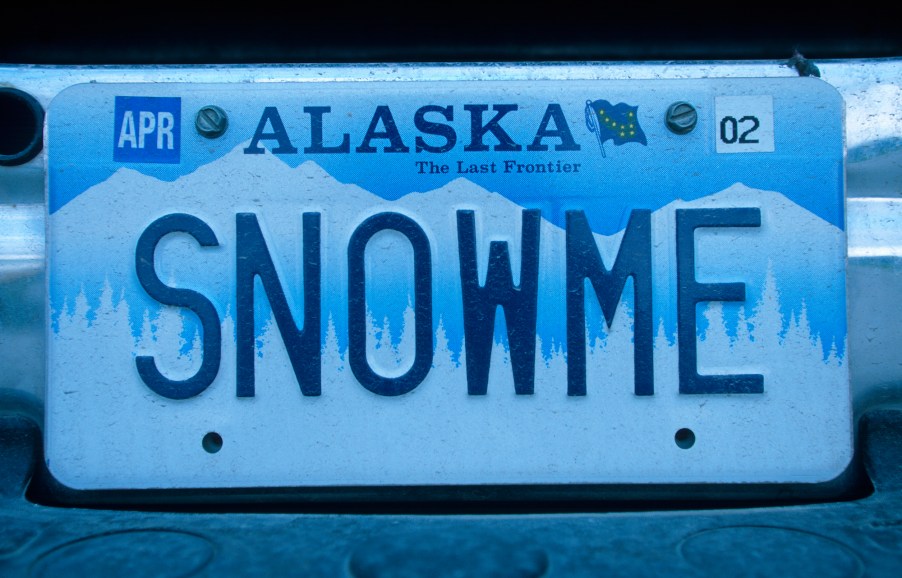 A blue and white Alaska vanity license plate reading, "Snow me"