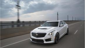 a white 2019 cadillac CTS at speed on an urban bridge