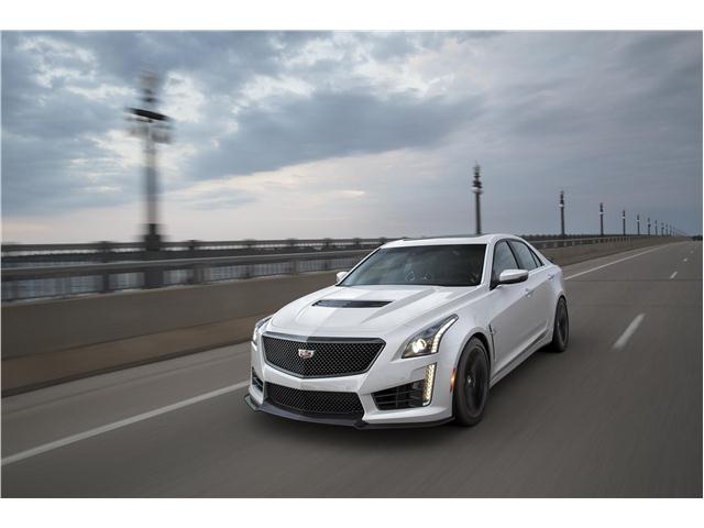 a white 2019 cadillac CTS at speed on an urban bridge