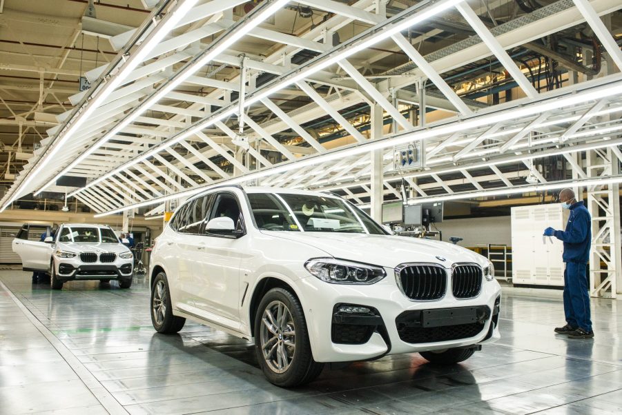 A worker wearing a protective face mask checks the bodywork of an BMW X3 sport utility vehicle (SUV) in a light tunnel at the BMW South Africa Pty Ltd. Rosslyn plant