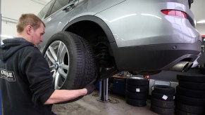 An auto mechanic changes the tires on a car