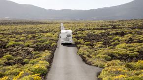 An RV driving down an empty road.