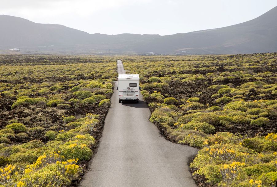 An RV driving down an empty road.