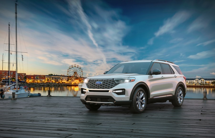 A white 2021 Ford Explorer sits near the water with a beautiful sunrise behind