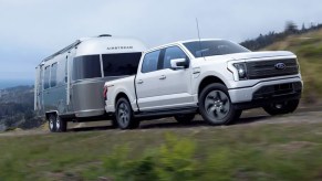 The 2022 Ford F-150 Lightning towing an RV up a curvy road