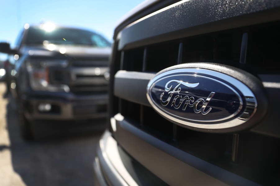 Ford F-150 trucks sit in the sun on at a dealership.