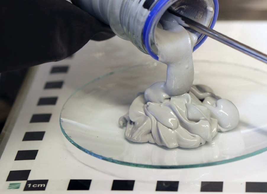 A researcher scrapes out Fraunhofer Institute PowerPaste for hydrogen fuel-cell vehicles onto a glass plate