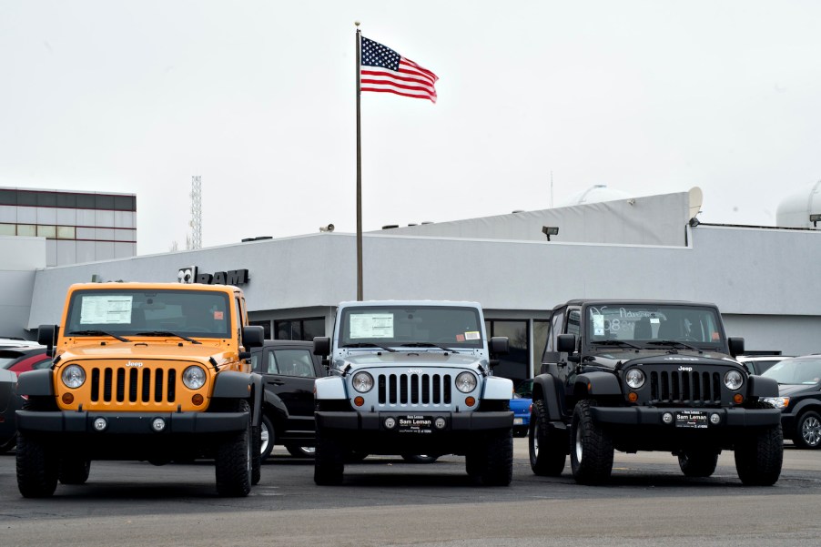 A U.S. flag flies over a car dealership.