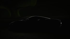 A dark imagine hiding everything about the 2022 McLarent Artura besides a sliver of light that highlights the car's silhouette