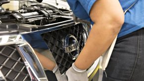 A worker installs a grill on a Nissan Frontier PRO-4X