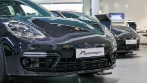 Panamera luxury automobiles, manufactured by Porsche SE, sit on display in the showroom at the Porsche Automobil Holding SE center in Hamburg, Germany