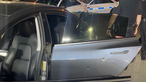 An image of a Tesla Model 3's door showing bullet holes.