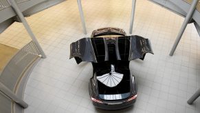 A black Tesla Model X with the falcon-wing doors open is on display in the new Tesla Service Center