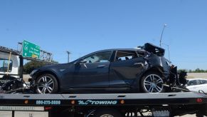 Blue Tesla on trailer after crash