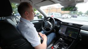 A driver sits behind the wheel of an autonomous car