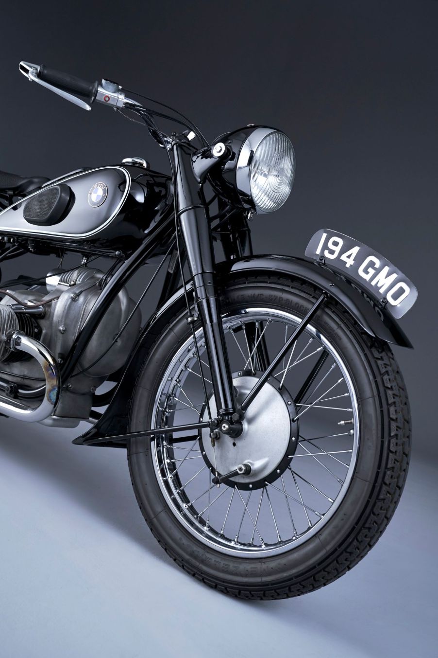 The front half of a black 1936 BMW R 5 motorcycle, showing the forks and the front drum brake assembly