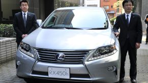 Japan's auto giant Toyota Motor managing officer Kazuo Ohara (R) introduces the company's newly designed Lexus RX 450h hybrid SUV with a 3.5-litre V6 engine