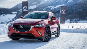 A red 2017 Mazda CX-3 parked in the show with Mazda flags in the background