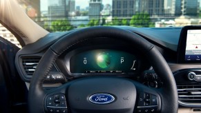 The black steering wheel and instrumentation panel of a 2020 Ford Escape Hybrid compact crossover SUV