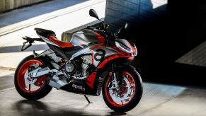 A silver-and-red 2021 Aprilia Tuono 660 by a concrete ramp