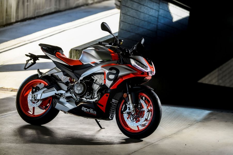 A silver-and-red 2021 Aprilia Tuono 660 by a concrete ramp