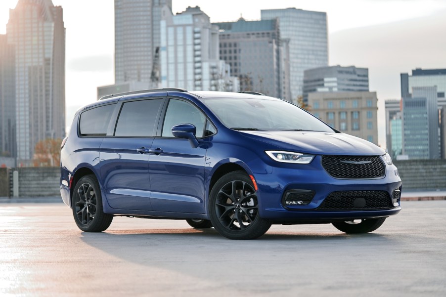 A royal-blue 2021 Chrysler Pacifica Limited AWD, with black wheels and a black grille, parked in front of a cityscape