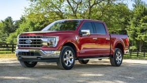 A red 2021 Ford F-150 Diesel Lariat parked on display with trees in the background